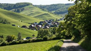 Paysage belge paisible avec collines vertes et village pittoresque.